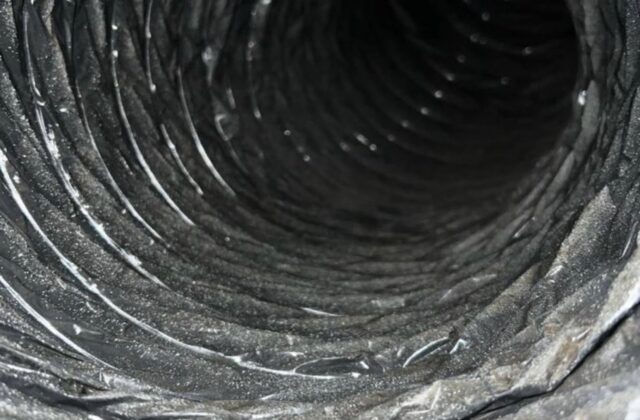 Dust-lined flexible AC duct interior before cleaning